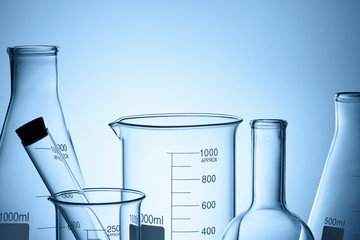 Wall Mural - laboratory glassware set with reflections on blue background