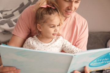 Wall Mural - Father and his daughter reading book on floor in children room