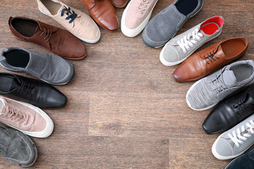 Canvas Print - Different male shoes on wooden floor