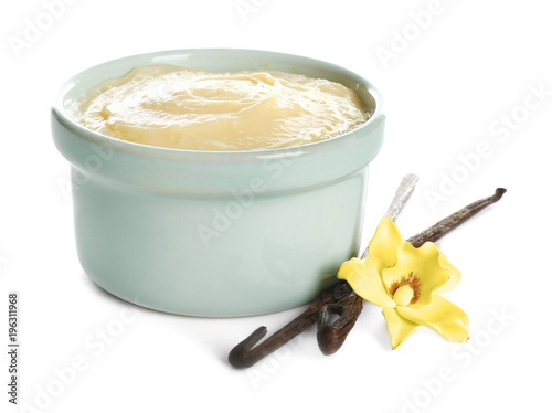 Cuadros en Lienzo Tasty vanilla pudding in ramekin and sticks with flower on white background