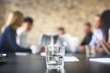 © Africa Studio - Glass of water and blurred office meeting on background. Finance trading