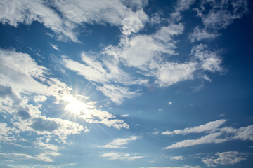 Wall Mural - sun rays against a blue sky in the clouds