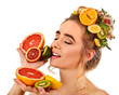 Hair and facial mask from fresh fruits for woman concept. Girl holds halves of grapefruit. Woman in profile is testing a new diet. Improvement of skin condition.