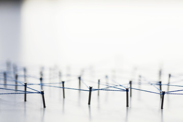 Poster - A large grid of pins connected with string. Communication, technology, network concept