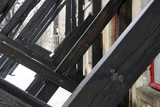 Fototapeta  - Wooden boards supporting old building from ruining. Concept of long-term support relationship closeup