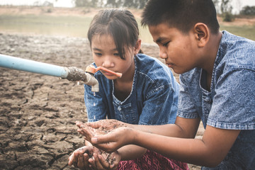 Sad children want to drink some water on crack ground , Concept drought and shortage of water crisis