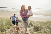 Family Walking Up A Sand Dune