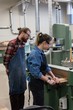 © Wavebreak Media - Male and female carpenters working together on vertical cutter