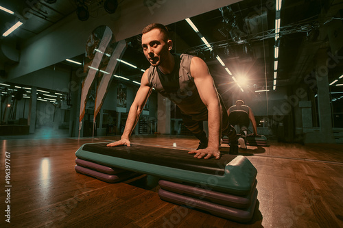 Fotografie, Obraz The man is exercising his legs on the stepper