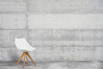 Designer, modern armchair in grey, loft style interior with concrete wall