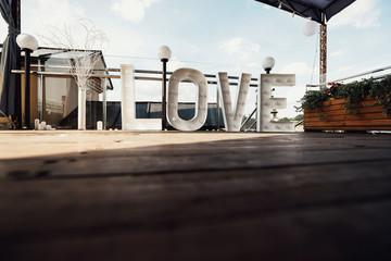 Wall Mural - Large letters LOVE stand before a wall