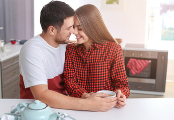 Poster - Cute young lovely couple drinking tea in kitchen