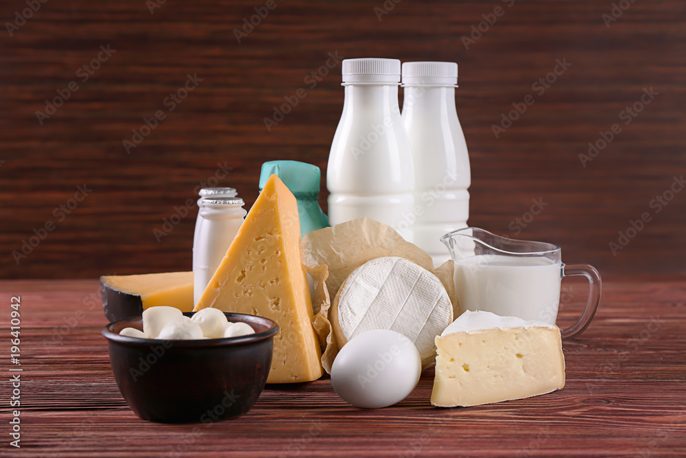 Different dairy products and egg on wooden table