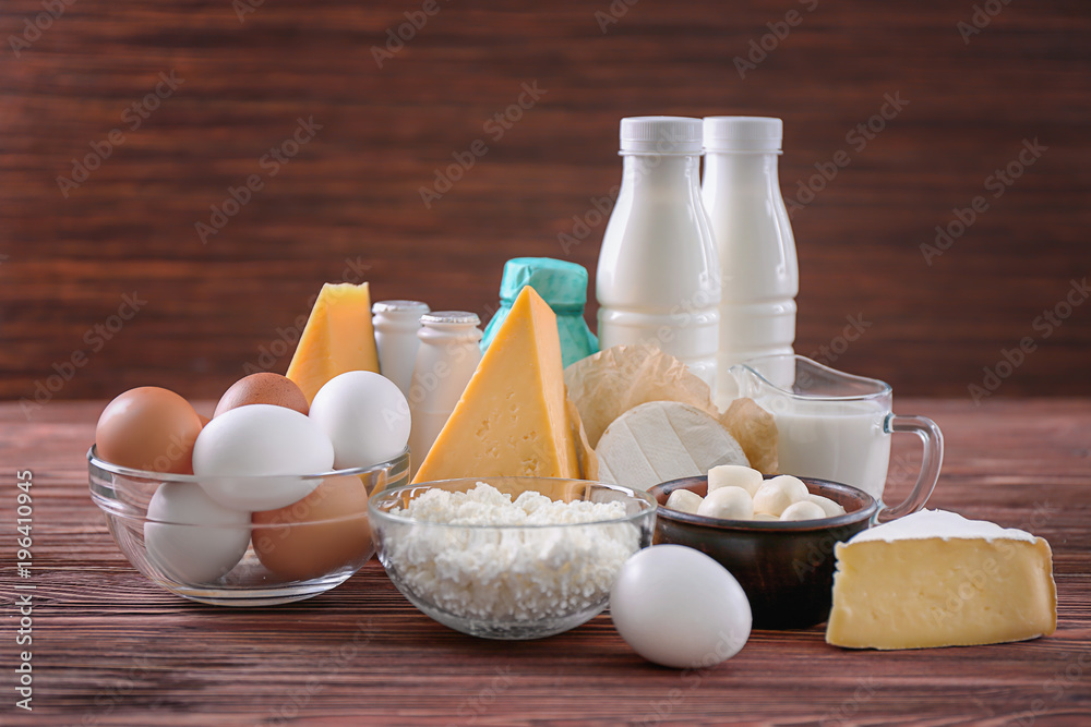 Different dairy products and eggs on wooden table