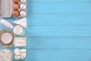 Wall Mural - Different dairy products and eggs on color wooden background