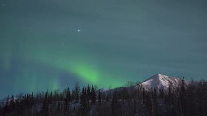 Wall Mural - Time Lapse of Green Northern Lights. Snowy Mountain and Trees at Winter Night.