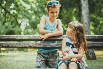 Boy and happy girl sitting on the bench