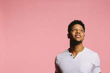 Portrait Of A Cool African American Man Looking Up, On Pink Background