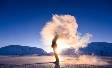 Wall Mural - boiling water frost in polar arctic sky in norway svalbard in longyearbyen man mountains