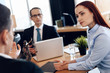 © freeograph - Red-haired beautiful woman listens attentively to man looking at divorce attorney.