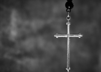 closeup photo of the silver cross in black and white tone. cross is a principal symbol of the christ