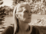 Fototapeta Psy - woman in deep thought on a sunny day sepia portrait
