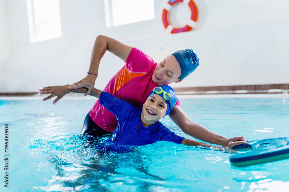 Boy having a swimming lesson with instructor - obrazy, fototapety, plakaty 