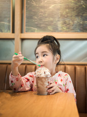 Beautiful asian girl drinking iced chocolate in the cafe, use  a straw