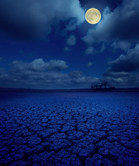 Wall Mural - full moon in clouds over cracked earth