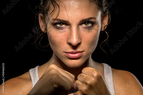 Fotomural Intense female fighter stare with fist up in self defense training, powerful and