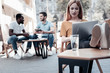 © zinkevych - Always ready to work. Selective focus on a motivated young woman relaxing in a chair with her legs on a table and looking at a screen of her laptop while working outdoors.