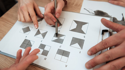 Man's hand holds pencil to make a mark on graphic test. Man is passing psychological graphic test.