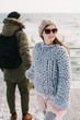 © LIGHTFIELD STUDIOS - stylish girl in merino wool sweater holding hands with boyfriend on winter quay at the sea
