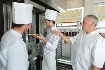 two bakers in bakery or bakehouse baking pretzels