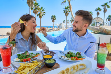 Wall Mural - Young couple eating in a pool restaurant