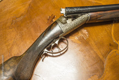 Fotografija Beautiful hunting rifle on inlaid table