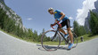 LOW ANGLE: Pro biking athlete training hard in nature on advanced road bicycle.