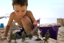 Boy Building Sandcastles And Playing With Toys On Beach