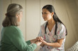 © Erickson Stock - Smiling young nurse comforting a senior woman.