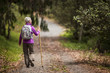 © Erickson Stock - Mature woman hiking on leafy forest trail