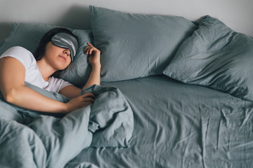 Wall Mural - woman sleep in eye patch in grey bed. copy space