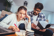 © Mediteraneo - Woman and man doing paperwork together, paying taxes online on notebook pc