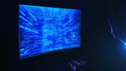 Poster - a man hacker in a hood in a dark room works with the program code