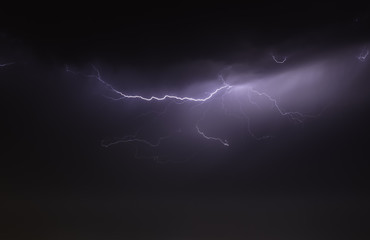 Wall Mural - lightning bolts reflection over the sea. taken during a thunderstorm over the ocean with clouds in the background