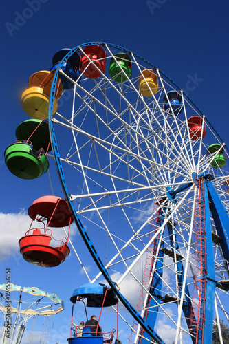 Foto Colourful Ferris Wheel over the blue clear sky with red, green, blue and yellow