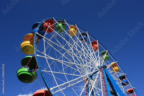 Foto Colourful Ferris Wheel over the blue clear sky with red, green, blue and yellow