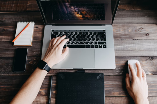 Man designer is working using laptop computer and graphics tablet at home office. Professional occupation workplace