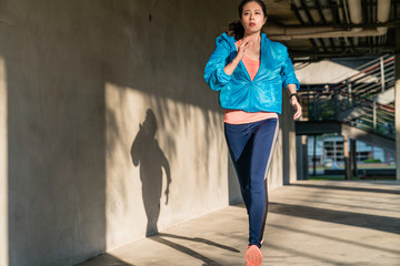 Wall Mural - Portrait of a woman running along city street.