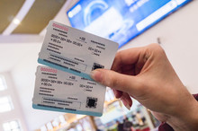 Two Tickets In A Woman's Hand For Travel By High-speed Train CRH
