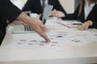 © xreflex - Hand of businessmen point to graph while Group discussing on stockmarket charts at office desk, they are business analyzing. brainstorming, teamwork, meeting concept...